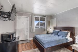 a bedroom with a bed and a flat screen tv at Selkirk Motel in Colville