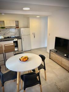 a kitchen with a table with a bowl of fruit on it at Departamento TERRANOVA un refugio tranquilo en el corazón de La Falda in La Falda +17 photos