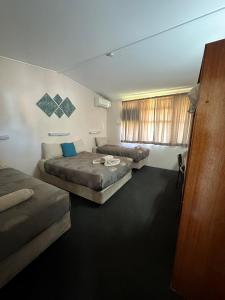 een hotelkamer met twee bedden en een bank bij Copper City Motel in Cobar