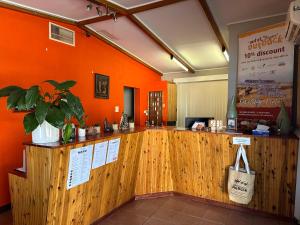 a restaurant with an orange wall and a counter at Copper City Motel in Cobar