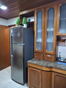 a kitchen with a stainless steel refrigerator and wooden cabinets at Apto 104 in Gramado +12 photos