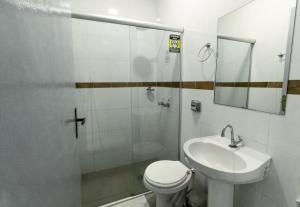 a bathroom with a shower and a toilet and a sink at Euro Hotel in Ubiratã +28 photos