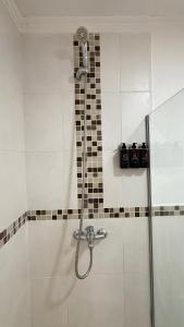 une douche avec une porte vitrée dans une salle de bain dans l'établissement Departamento Ama con estacionamiento para vehículos chicos, à Villa Dolores 12 autres photos