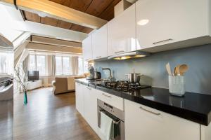 a kitchen with white cabinets and a black counter top at Grand Canal Boutique Hotel in Amsterdam