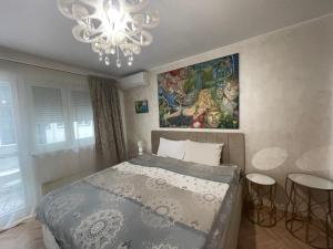 a bedroom with a bed and a chandelier at Dreamscape City Center in Belgrade