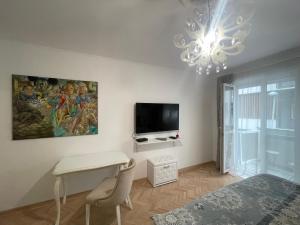 a bedroom with a desk and a tv and a chandelier at Dreamscape City Center in Belgrade
