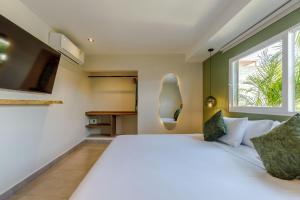 a bedroom with a large white bed and a window at De la cruz Studio Apartments in Cartagena de Indias