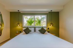 a bedroom with a large white bed with a window at De la cruz Studio Apartments in Cartagena de Indias
