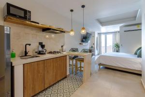a kitchen with a sink and a bed in a room at De la cruz Studio Apartments in Cartagena de Indias