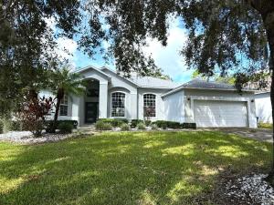 a white house with a garage at Elite Forest Hills Villa - Southern Dunes - Golf Course Views in Haines City