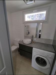 a bathroom with a washing machine and a sink at Studio Qu'importe, Jardin, Jacuzzi, Massage in Bandol +6 photos