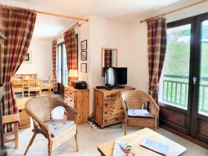 a living room with a tv and two chairs at Résidence Murgers - Appartement lumineux · A proximité des pistes · Balcon MAE-3004 in Saint-Martin-de-Belleville +6 photos