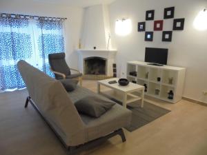 a living room with a couch and a tv at Lagos Charming Villas in Lagos