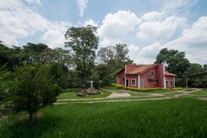 a small red house in a field of green grass at Pousada Ranchico in Brumadinho