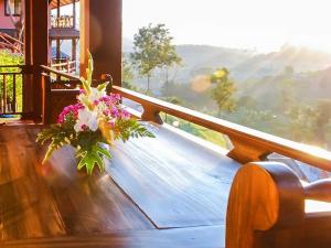 a vase of flowers sitting on a table next to a window at Insda Wellness Resort in Chiang Mai +201 photos