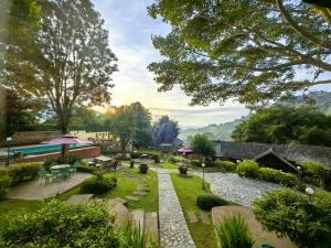 an image of a garden with tables and chairs at Insda Wellness Resort in Chiang Mai