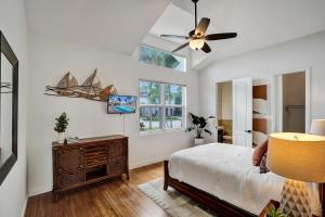 a bedroom with a bed and a ceiling fan at stunning waterfront villa in boca raton in Boca Raton +39 photos