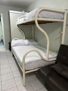two bunk beds in a room with a couch at Kitnet Flamingo Matinhos 31B in Matinhos +32 photos