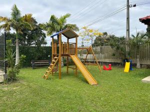 a playground with a slide in a yard at Kitnet Flamingo Matinhos 31B in Matinhos