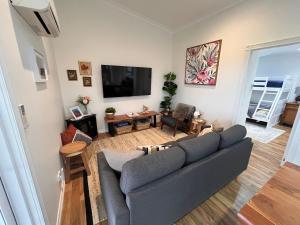 a living room with a couch and a flat screen tv at Wallawa on Hilltop in Ellesmere
