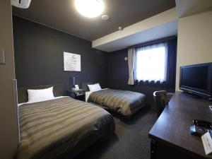 Postel nebo postele na pokoji v ubytování Hotel Route-Inn Susono Inter
