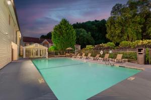 a swimming pool in a yard with chairs and a house at Best Western Mountainbrook Inn Maggie Valley in Maggie Valley