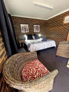 a hotel room with two beds and a chair at Squatters Homestead Motel in Casino