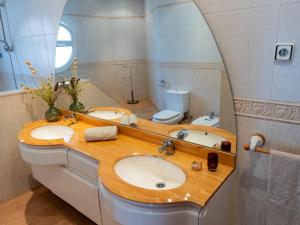 Un baño con dos lavabos y un espejo. en Casa Serenidad: Naturaleza, Jacuzzi & Parking en Cubelles - ES-332-10, en Cubelles 17 fotos más