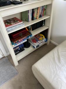 a book shelf filled with books next to a bed at Janie s Cottage Secluded Wine Country Home in Broke