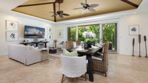 ワイコロアにあるHALE OHONU Stylish 3BR Detached Home Close to KaMilo Poolsのテーブルと椅子のあるダイニングルームとリビングルーム