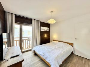 une chambre avec un lit et une grande fenêtre dans l'établissement Résidence Le Living Stone B - NOUVEAU CENTRE, PIED DES PISTES-Tout inclus MAE-0941, à Vars