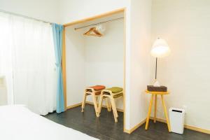 a bedroom with a bed and two chairs and a mirror at 貸切戸建て3beds Private House Sleep Man in Kagoshima