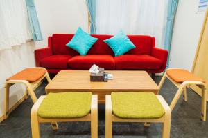 a living room with a red couch and a table and chairs at 貸切戸建て3beds Private House Sleep Man in Kagoshima