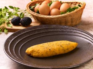 a tortilla on a plate with eggs and a basket of fruit at Hotel Granvia Kyoto in Kyoto