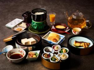 a table with various dishes of food and a teapot at Hotel Granvia Kyoto in Kyoto
