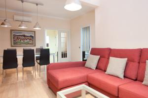 バルセロナにあるAB Eixample Viladomat Apartmentsのリビングルーム(赤いソファ、テーブル付)