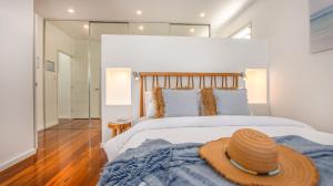 Un dormitorio con una cama grande con un sombrero encima. en Verano, en Casuarina 47 fotos más