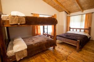 two bunk beds in a room with wooden floors at Hotel Santa M la Cocha in Pasto