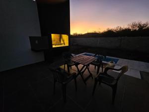 Una mesa y sillas en una habitación con una puesta de sol. en CountryHome Tierra Alta, en Villa San Nicolás
