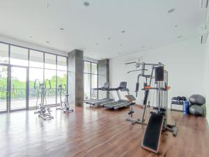 a gym with several treadmills and exercise bikes at Comfy and Modern Studio at Cordova Edupartment Semarang Apartment By Travelio in Semarang