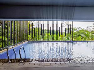 a swimming pool with a fence around it at Comfy and Modern Studio at Cordova Edupartment Semarang Apartment By Travelio in Semarang