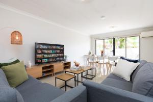 a living room with two blue couches and a tv at Smart Suites Self Check-in Apartments - S Stockport in Brisbane