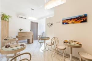 uma sala de estar com mesas e cadeiras e um piano em Sette Colli Guesthouse em Cagliari