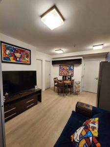 サンパウロにあるApê acolhedor à 5 min Aeroporto Congonhasのリビングルーム(薄型テレビ、テーブル付)
