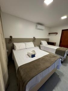 two beds in a hotel room with two beds at Mar de Maragogi Flats in Maragogi