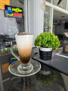 a cup of coffee on a table with a plant at DDINN BEACH GUESTHOUSE in Pattaya South