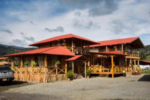 a large wooden building with red roofs at Hotel Santa M la Cocha in Pasto