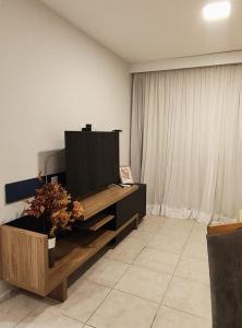 a living room with a flat screen tv on a cabinet at Flat Beira Mar Meireles in Fortaleza