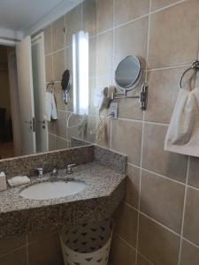 a bathroom with a sink and a mirror at Flat Beira Mar Meireles in Fortaleza
