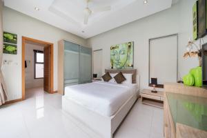 een witte slaapkamer met een groot wit bed. bij Relax & Enjoy Stay! Elegant 3BR Pool Villa Talosy in Rawai Beach +25 foto's